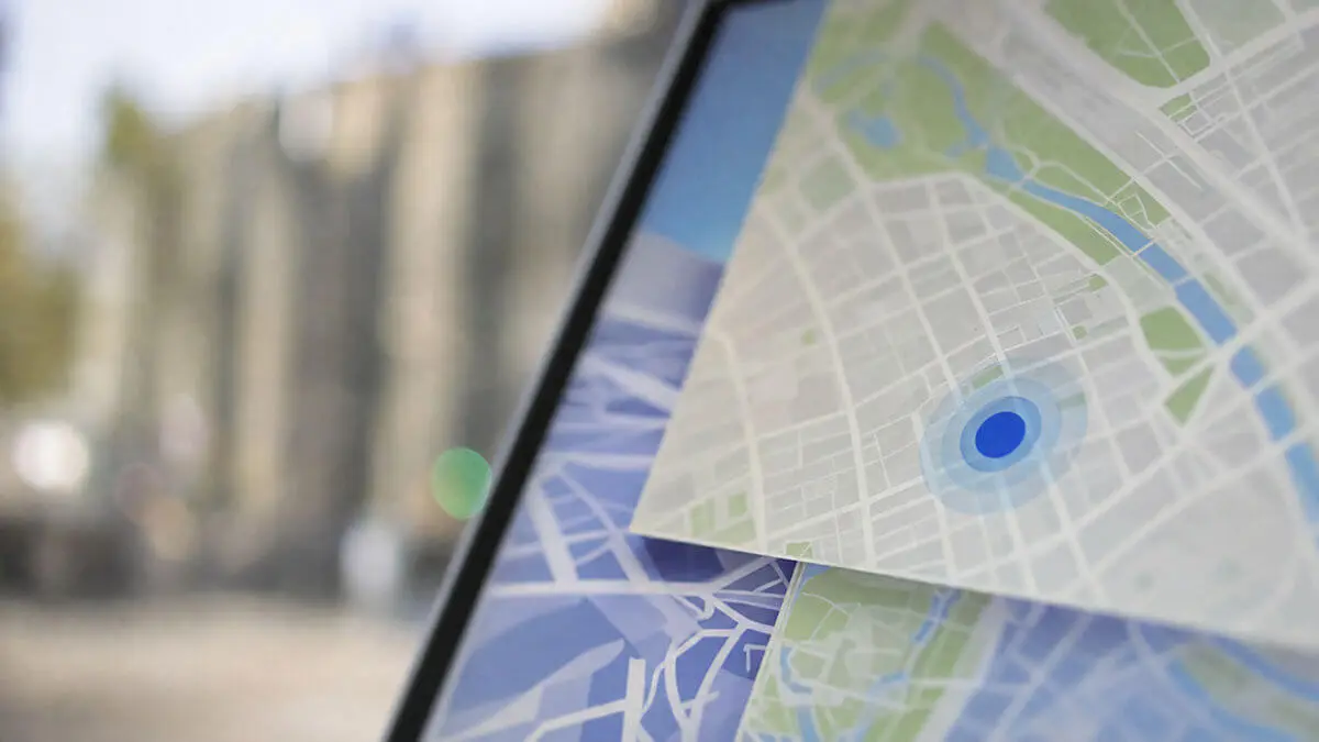 Pantalla con capas de mapa urbano superpuestas: carreteras y límites en capas translúcidas, iconos abstractos sin letras, sin