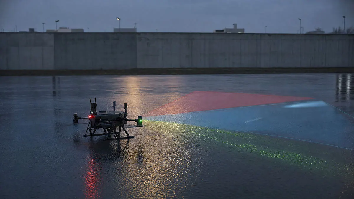 Escena de seguridad alrededor de un dron/robot: sombras en asfalto húmedo, haces de sensores distintos (térmico frío, radar t